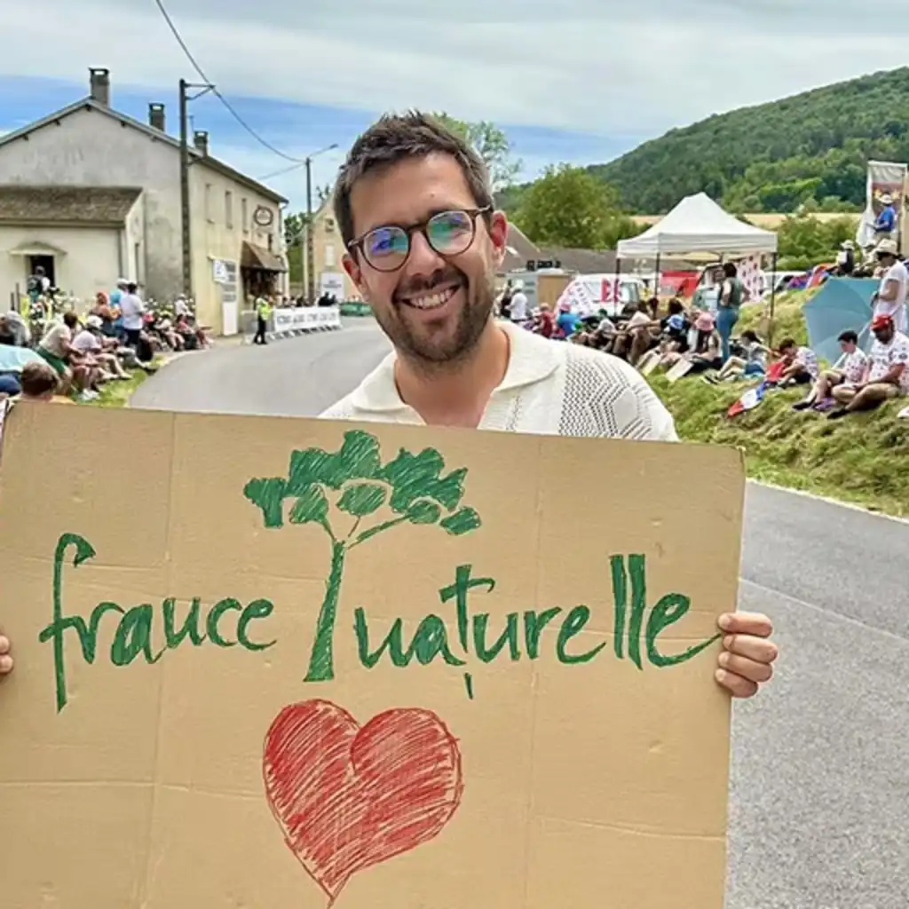 Ein Mann, der ein Schild mit der Aufschrift "france naturelle" und einem Herz hält