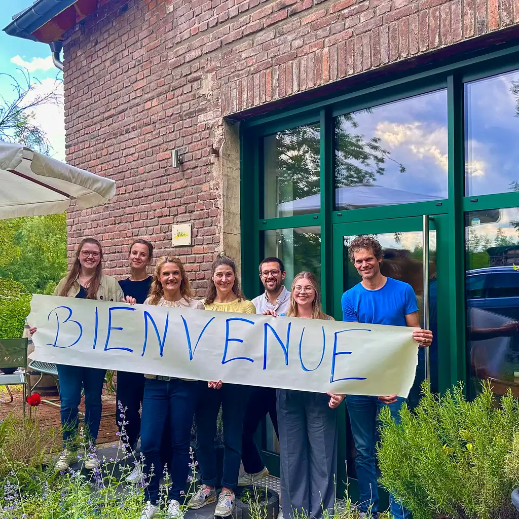 France Naturelle hält einen Banner Bienvenue vor dem Büro hoch
