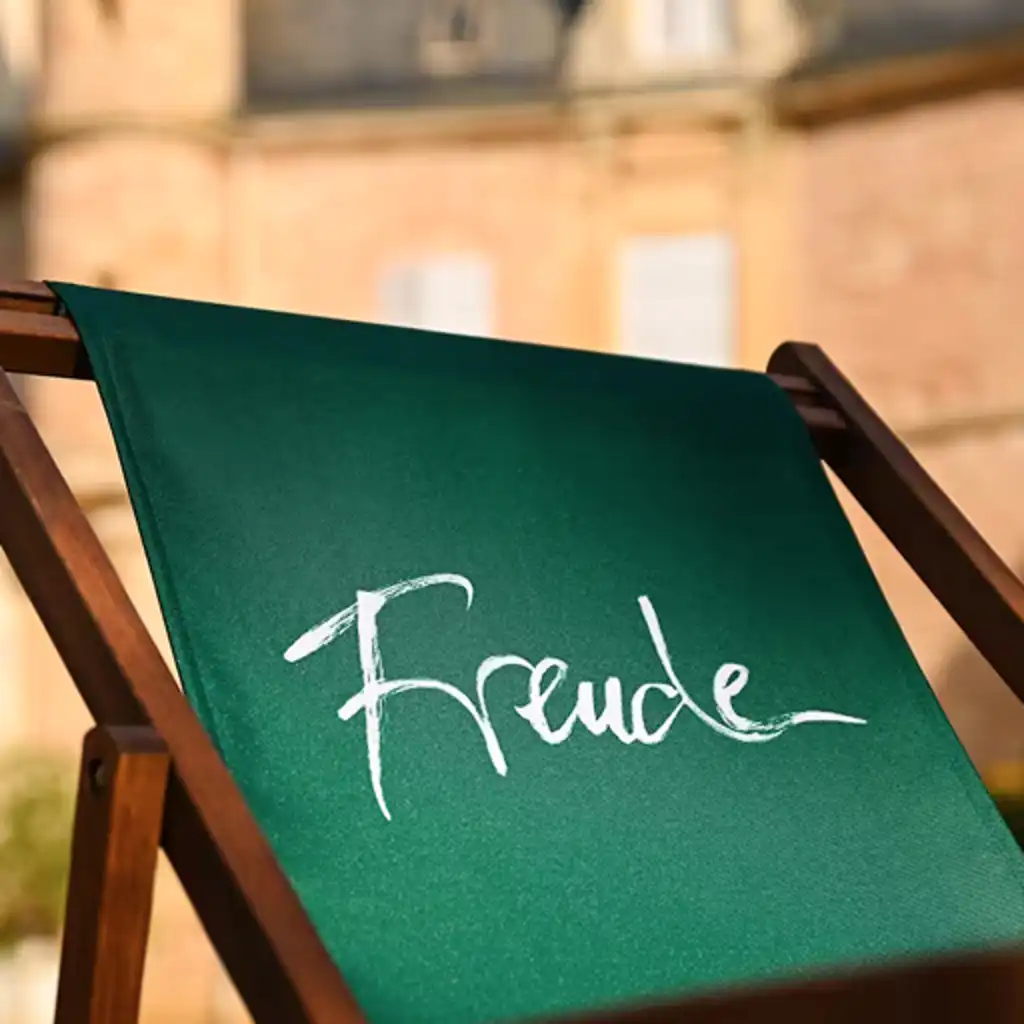 Ein grün bespannter Liegestuhl mit der Aufschrift "Freude"