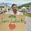 Ein Mann, der ein Schild mit der Aufschrift "france naturelle" und einem Herz hält