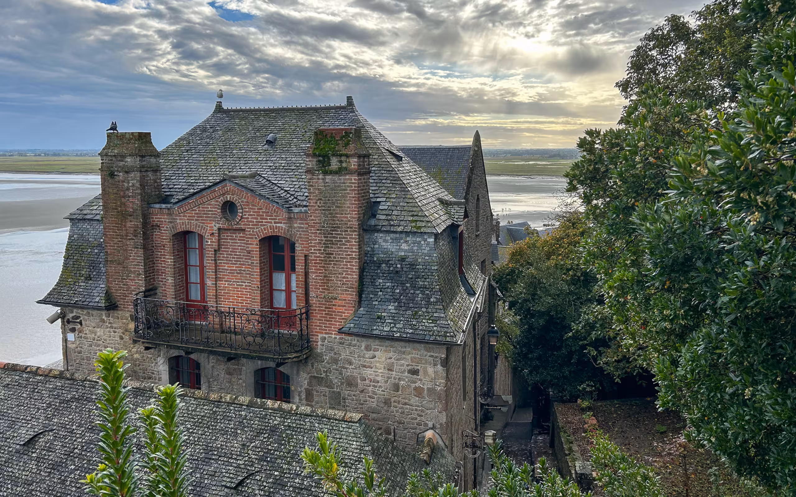 Ein schönes Steinhaus auf Mont-Saint-Michel mit dem Meer im Hintergrund