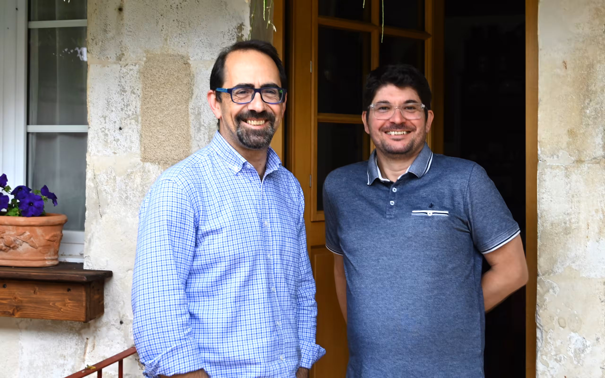 Die Gastgeber der alten Poststation im Burgund stehen lächelnd im Eingang