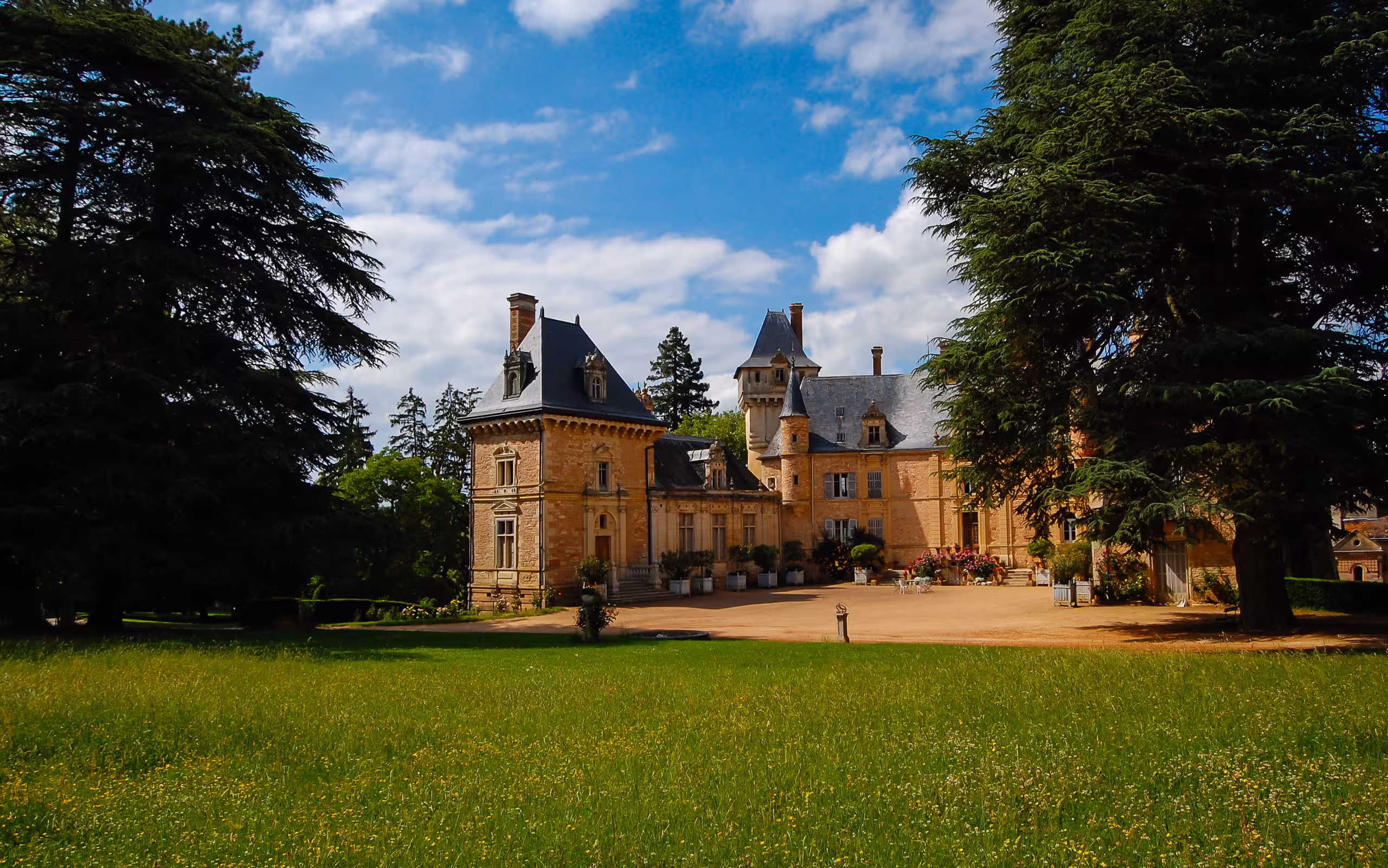 Der Garten des Schlosses im Burgund mit einer saftig grünen Wiese und einem großem Innenhof