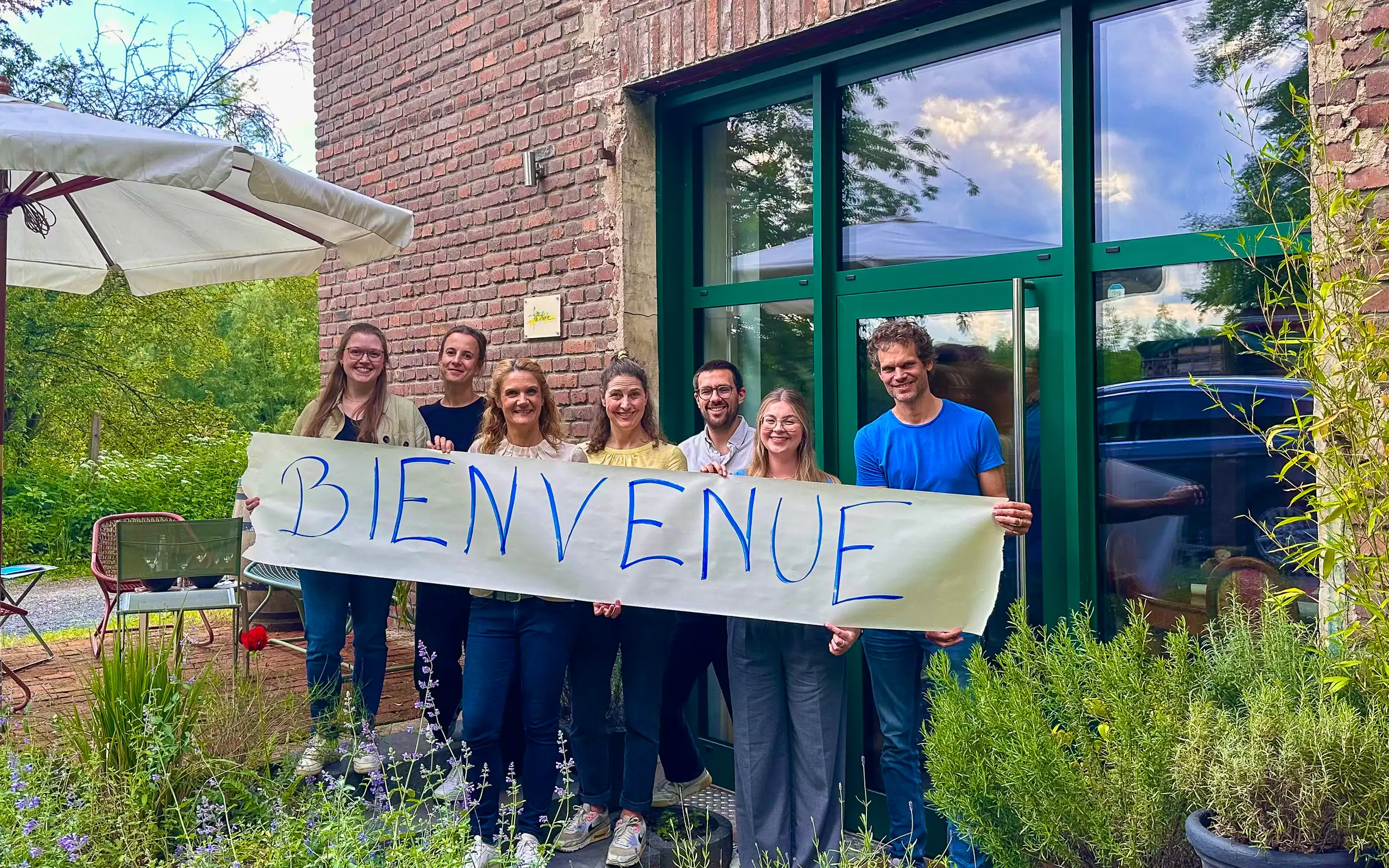 France Naturelle hält einen Banner Bienvenue vor dem Büro hoch