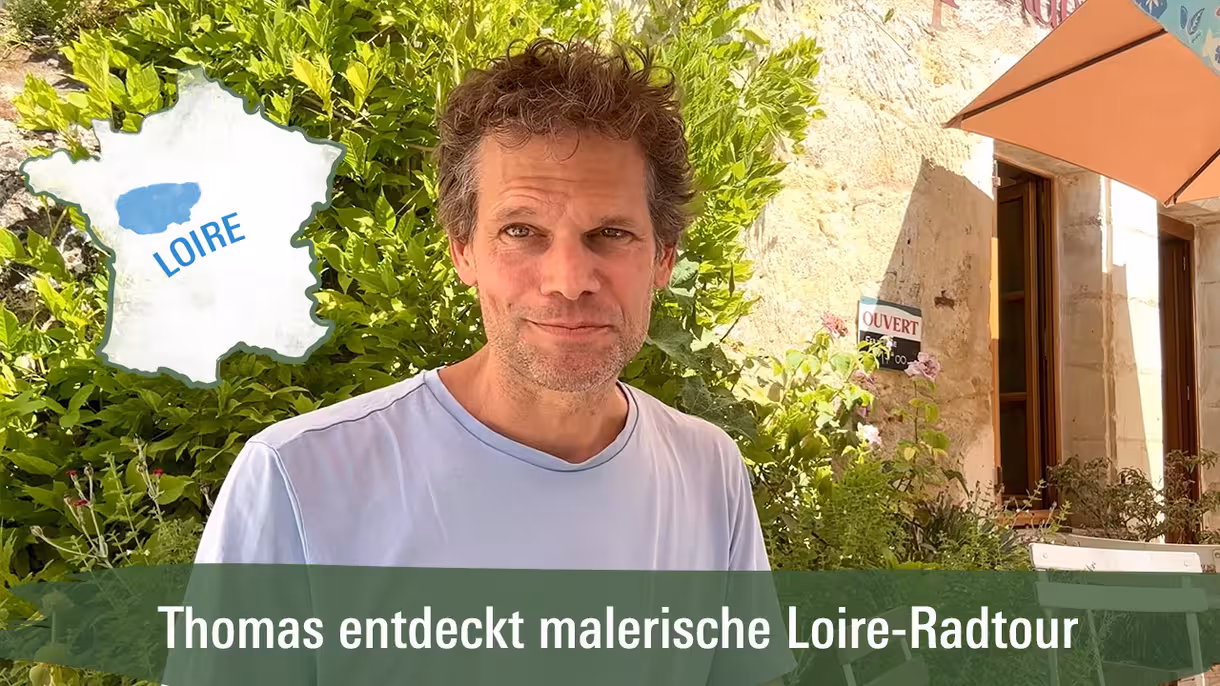 Ein Mann vor einem Cafe der über eine Radtour an der Loire erzählt