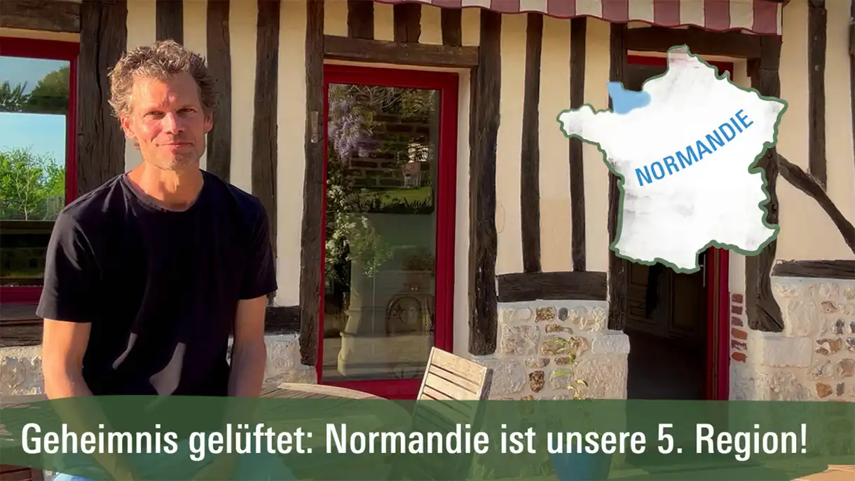 Mann vor einem Fachwerkhaus in der Normandie