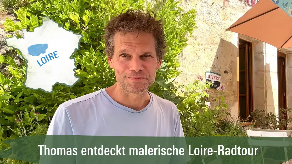 Ein Mann vor einem Cafe der über eine Radtour an der Loire erzählt